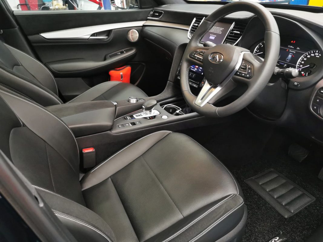 The Infiniti QX50 parked in the workshop, freshly coated.