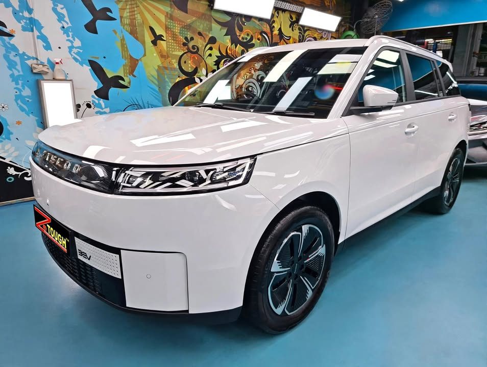 Front three-quarter view of a white Jaecoo J5 in the Revol Carz hall after coating.