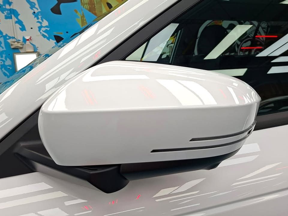White side mirror cap on the J5 reflecting the ceiling lights.