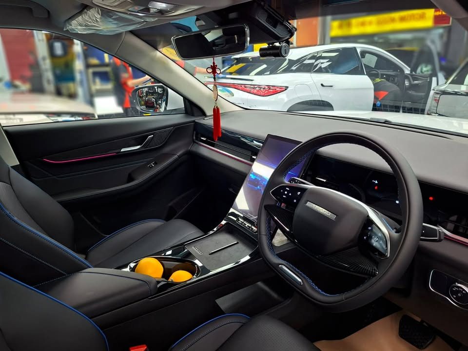 Cabin of the J5 with a black steering wheel and centre touchscreen.