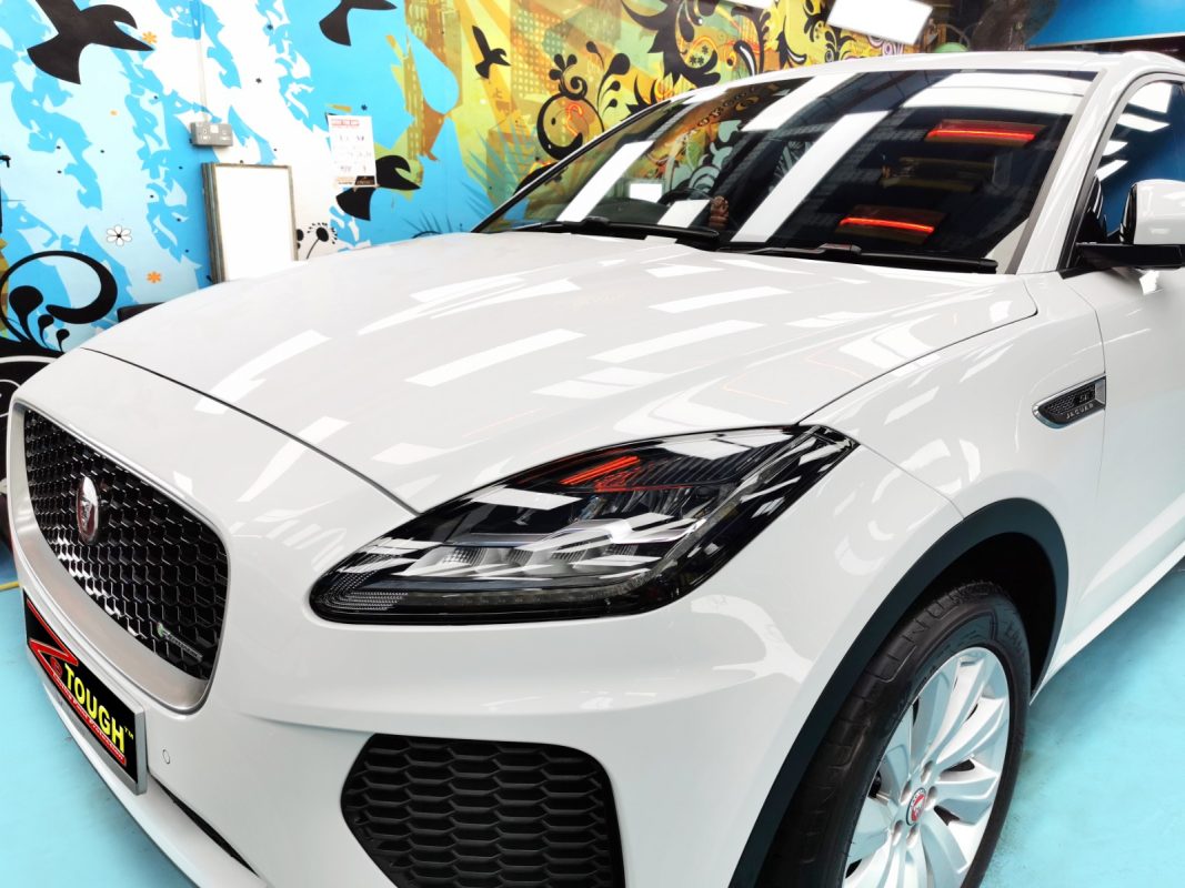 The white Jaguar E-Pace from a side angle after the ceramic coating.