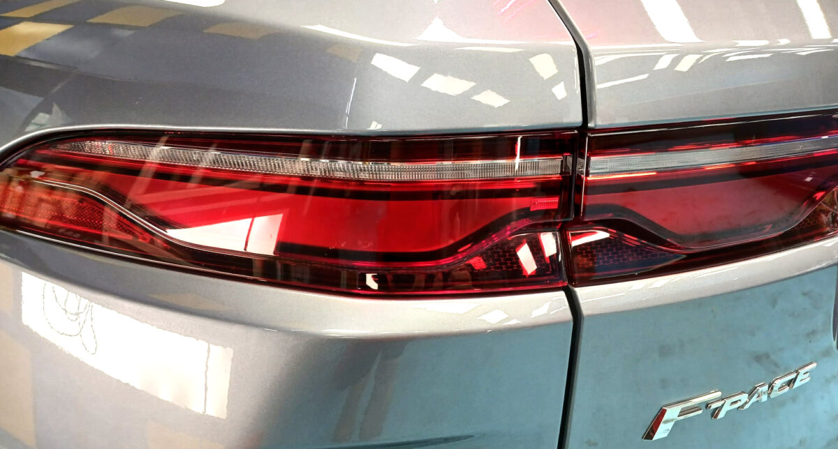 The coated bonnet of the Jaguar F-Pace under workshop lighting.