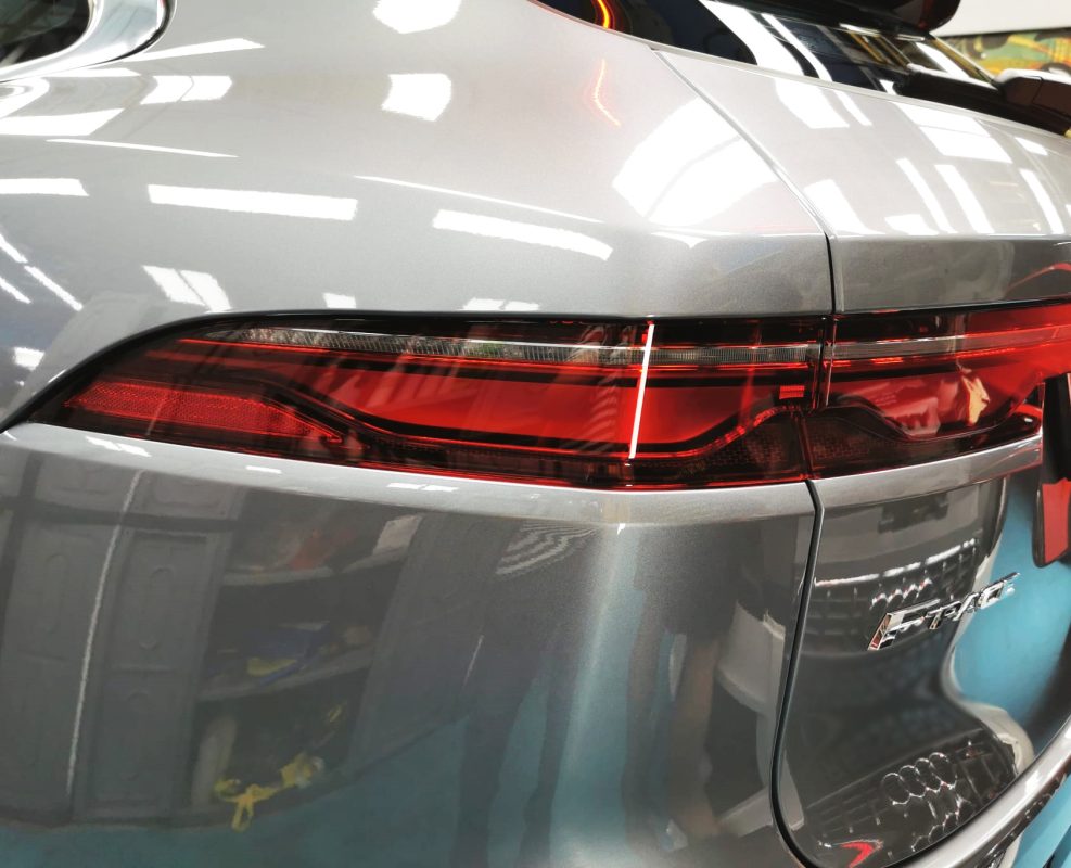 The coated bonnet of the Jaguar F-Pace under workshop lighting.