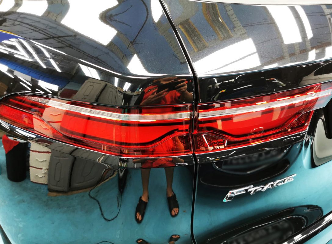 The coated bonnet of the Jaguar F-Pace under workshop lighting.