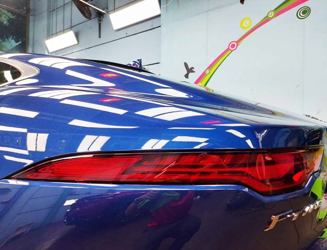 The coated bonnet of the Jaguar F-Type under workshop lighting.