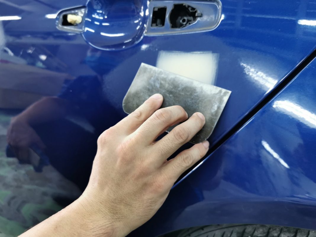 The XE's paintwork being examined and patched before spraying.