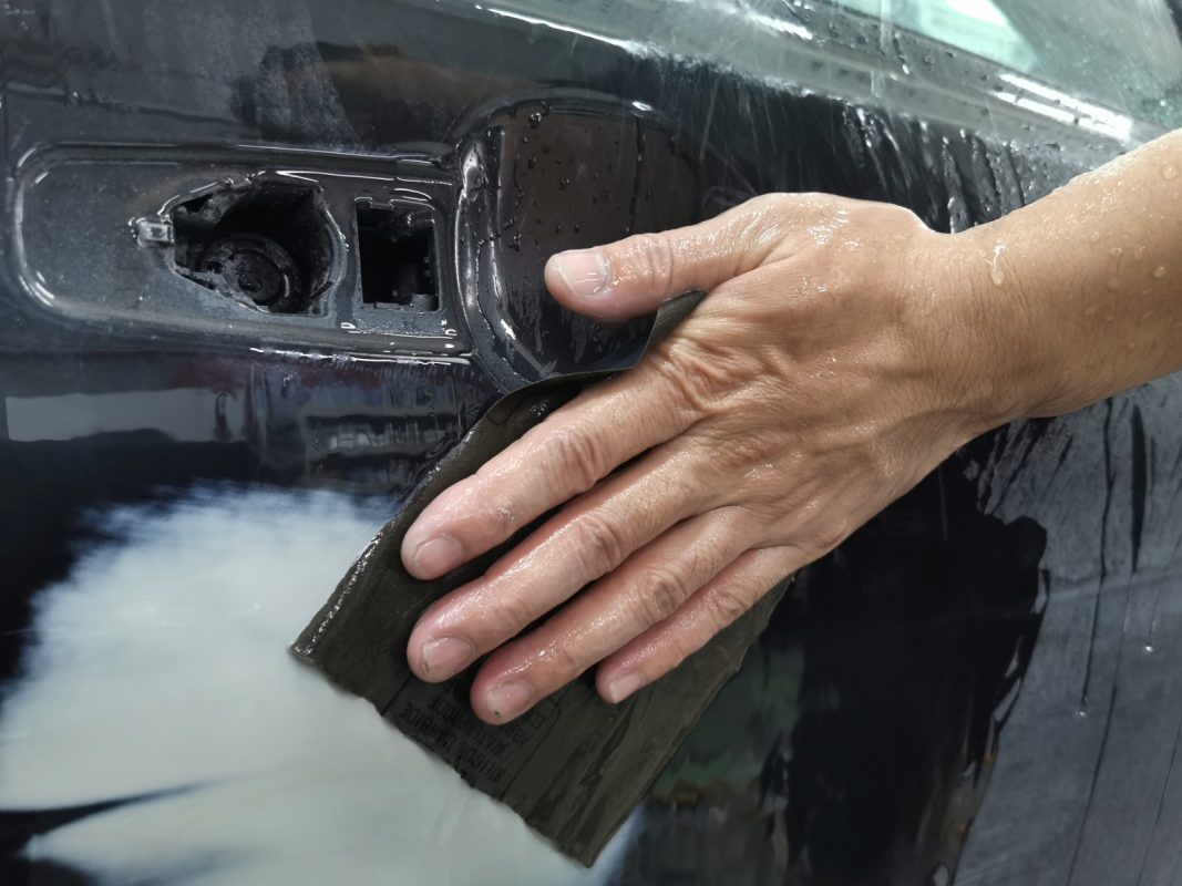 Wet-sanding the XF's panels to smooth the existing paintwork.