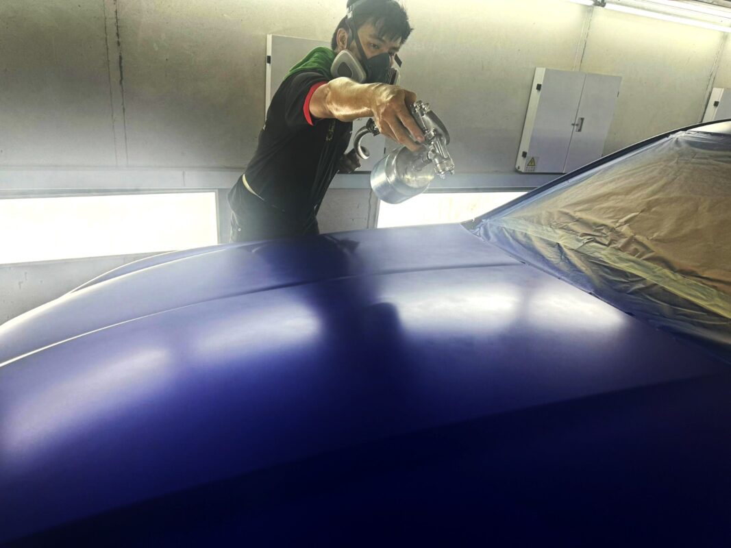 Fresh coat being applied to the Jaguar XF in the spray booth.