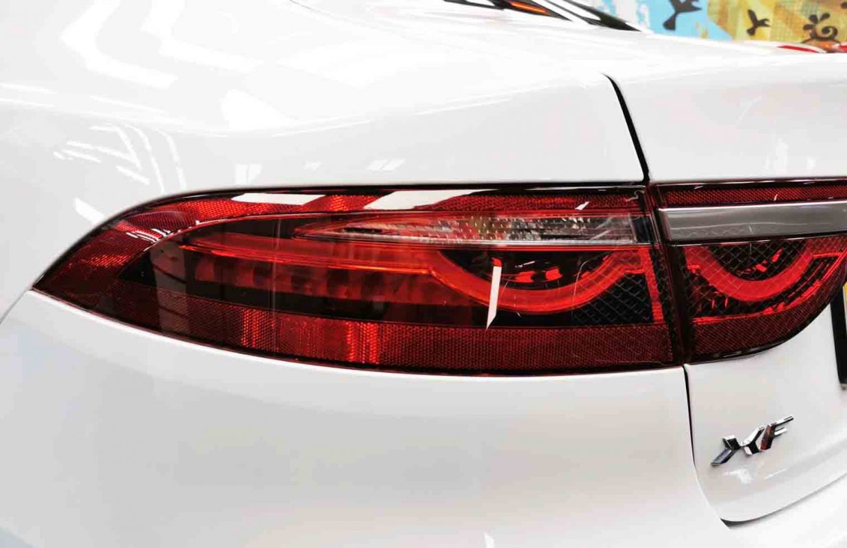 The coated bonnet of the Jaguar XF under workshop lighting.