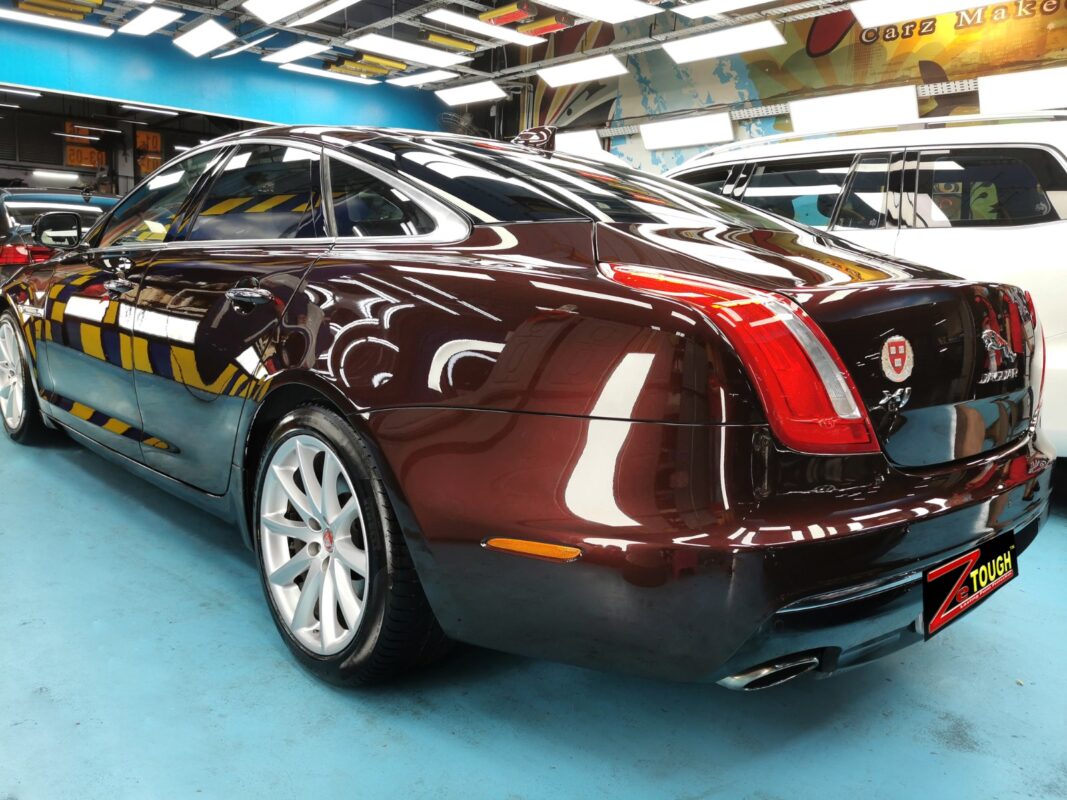 Dark maroon Jaguar XJ, glossy after its full respray.