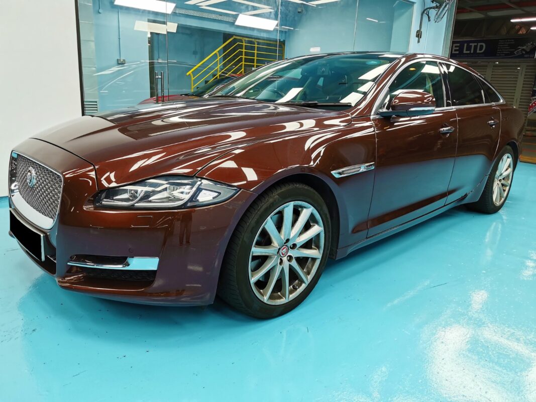 The dark maroon Jaguar XJ as it arrived at Revol Carz, paintwork scratched before the respray.