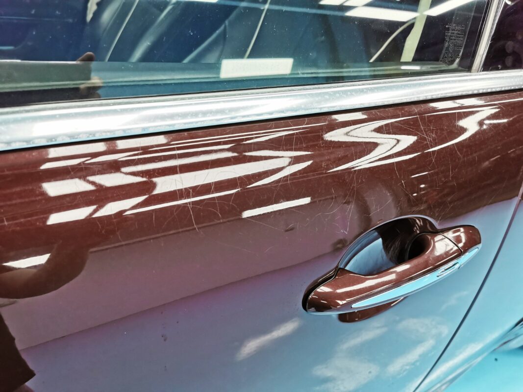 Close-up of scratches across a rear door of the Jaguar XJ before the respray.