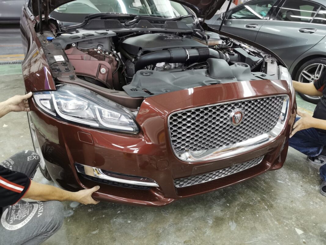 The Jaguar XJ's front bumper removed as the car is stripped down for the respray.