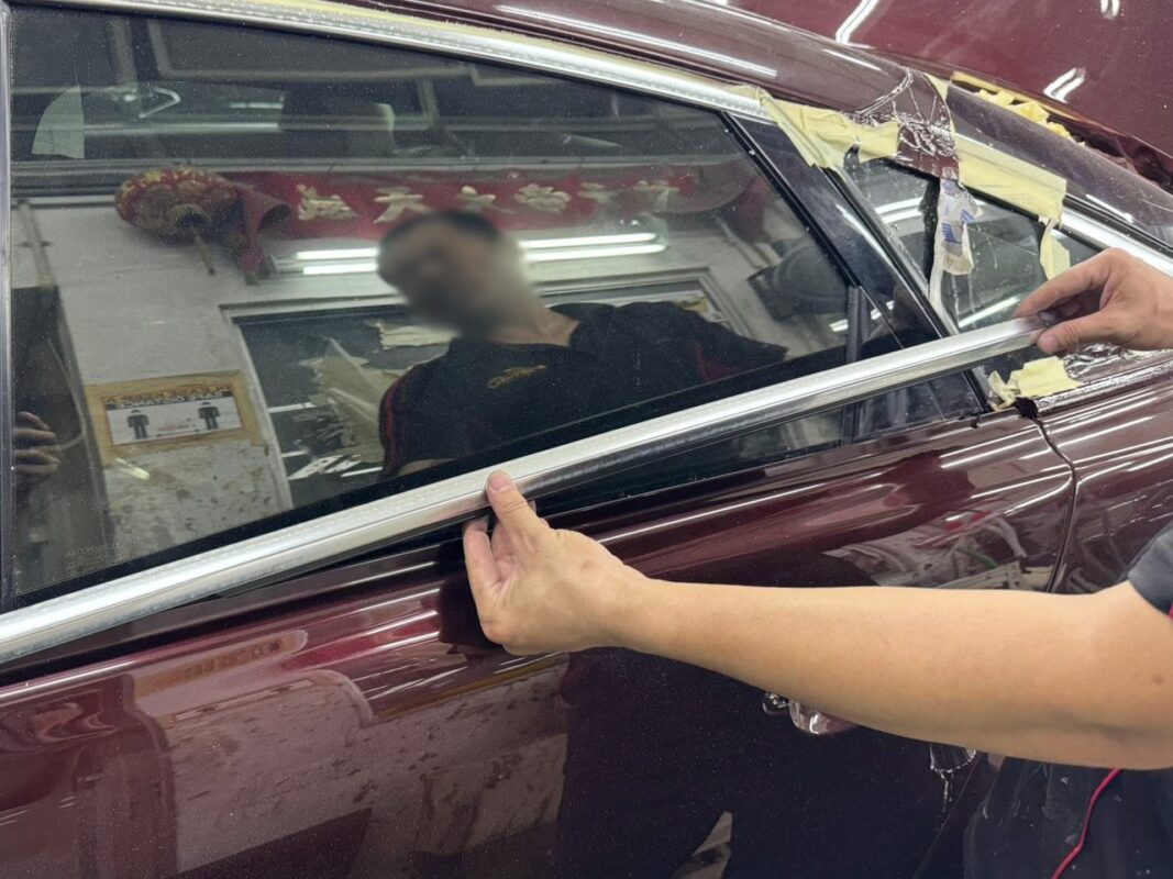 A Revol Carz painter laying the new coat onto the Jaguar XJ in the spray booth.