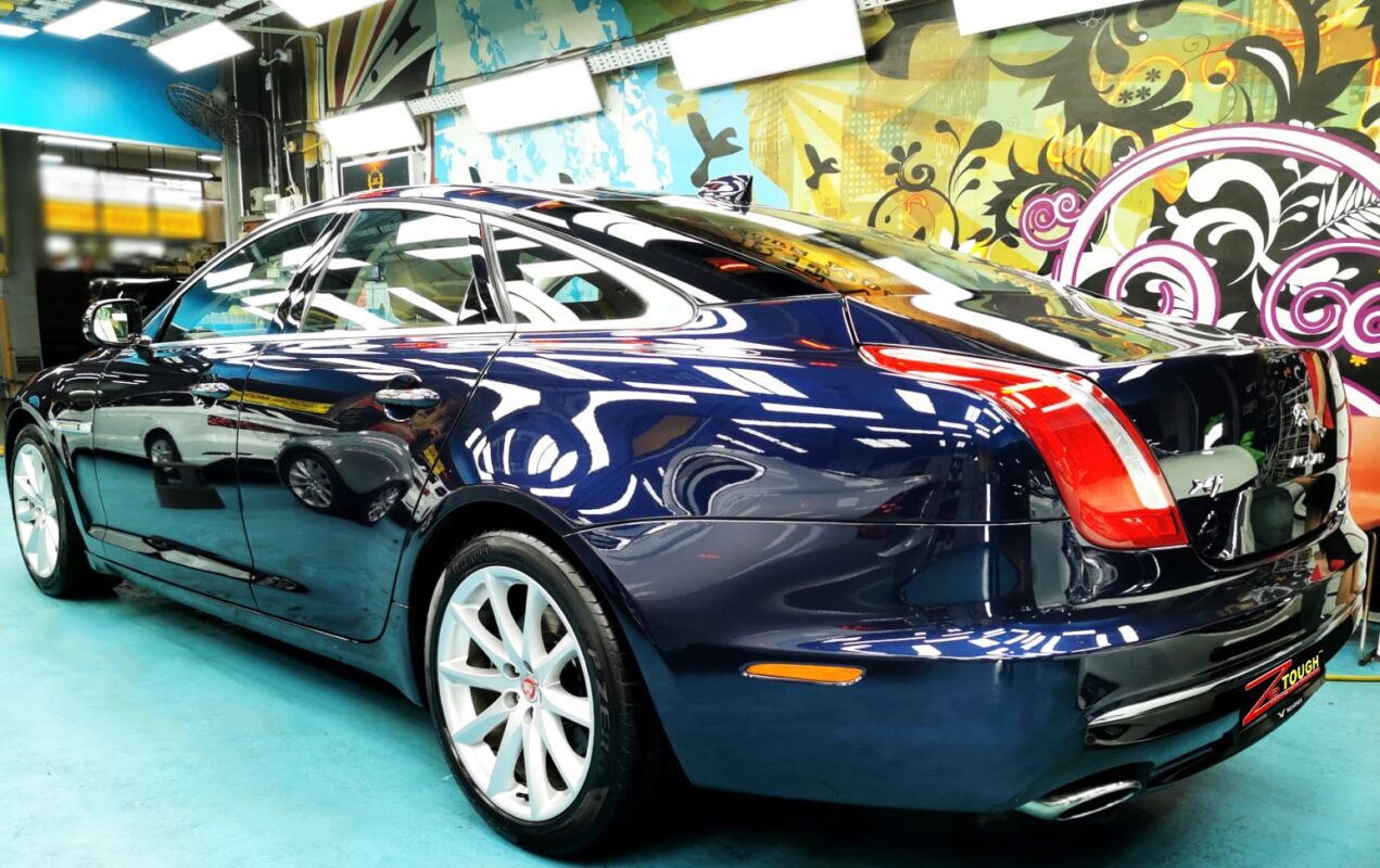 Rear quarter of the blue Jaguar XJ, glossy and protected.