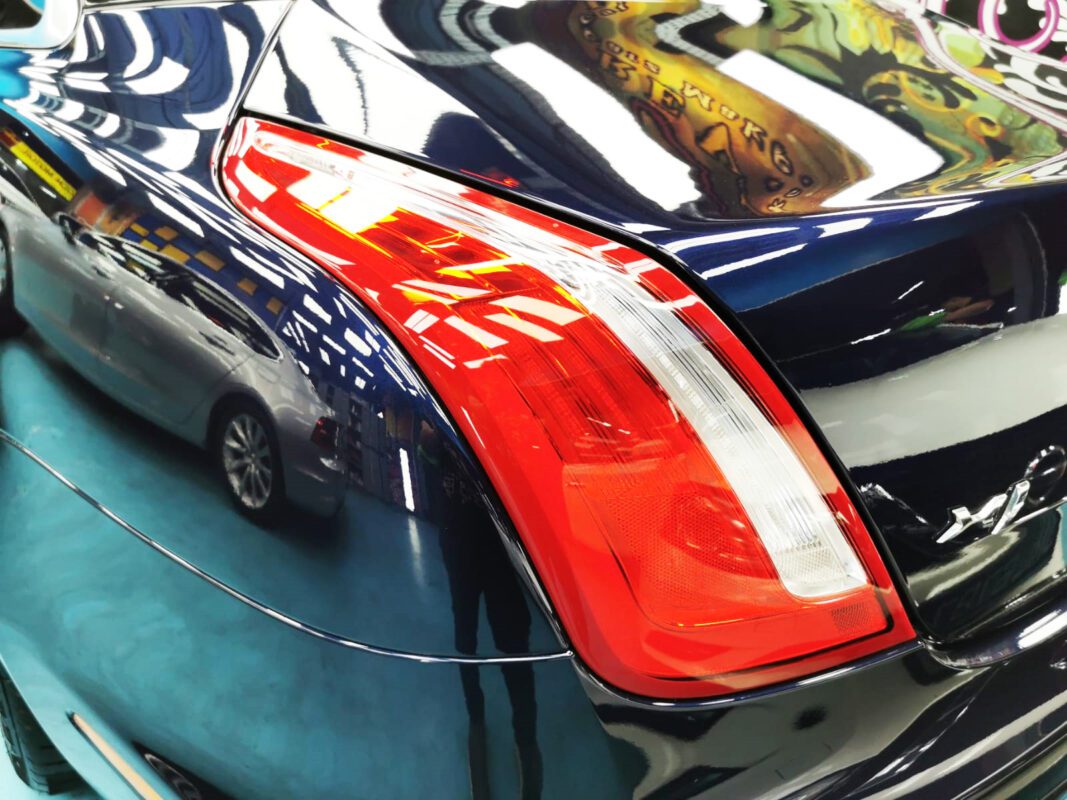 The coated bonnet of the Jaguar XJ under workshop lighting.