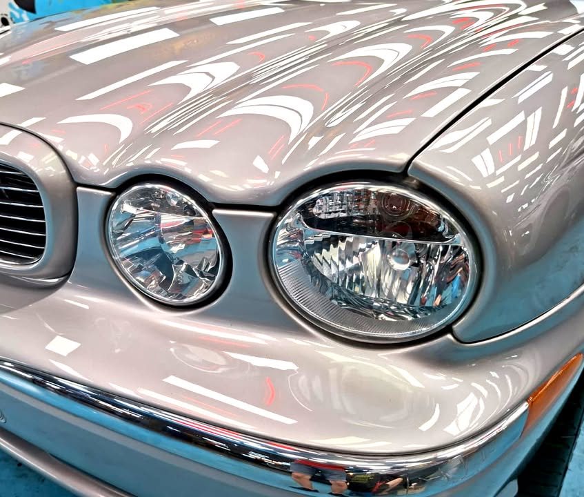 Close-up of the twin round headlights and chrome bumper trim.