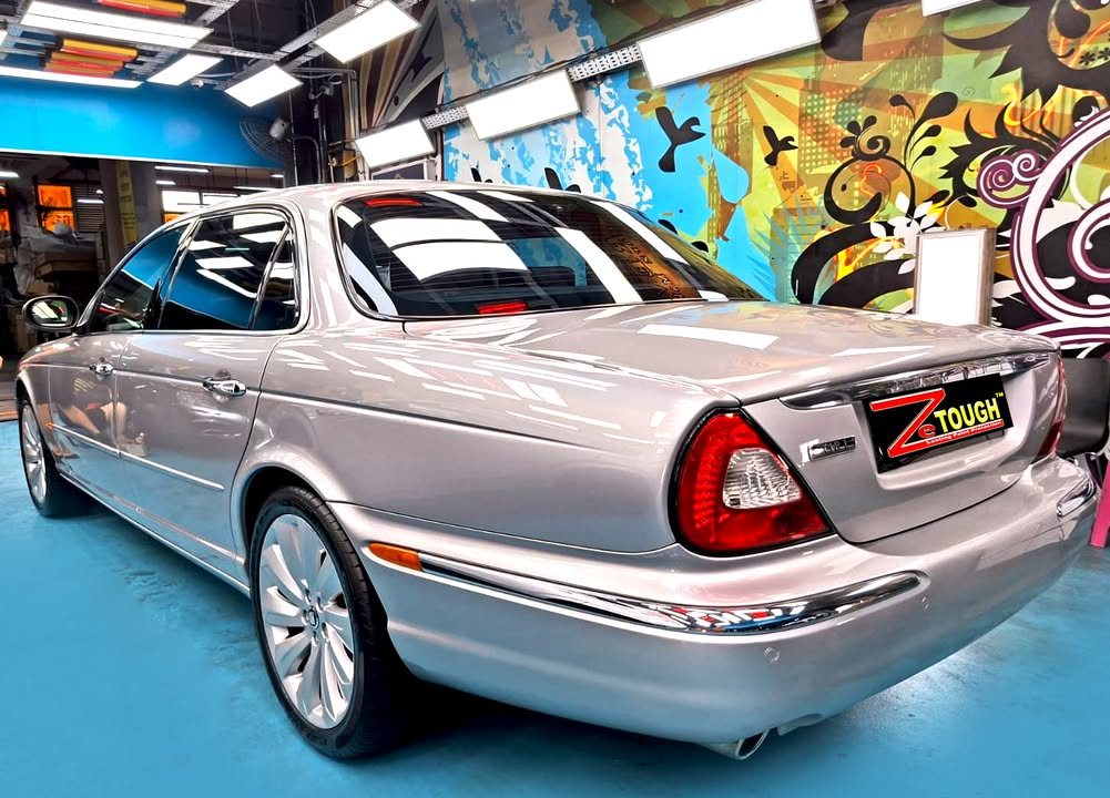 Silver Jaguar XJ8, rear three-quarter view, in the workshop.
