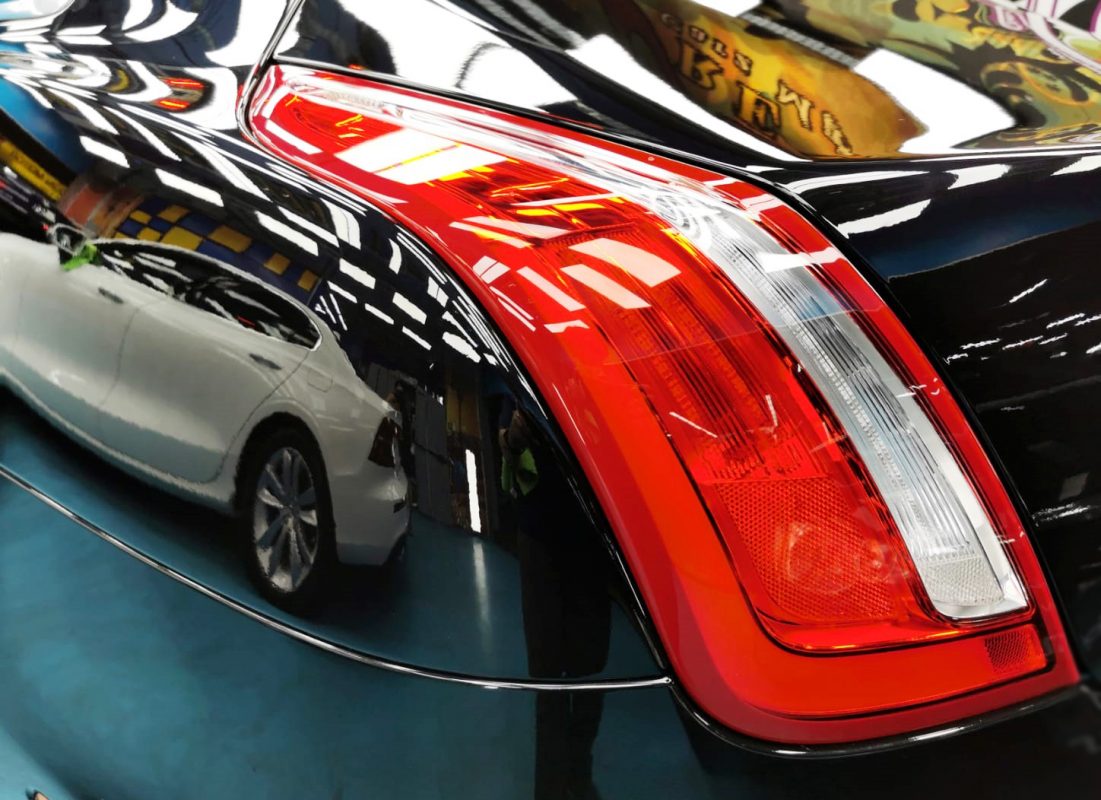 Bonnet of the Jaguar XJL under workshop lighting.