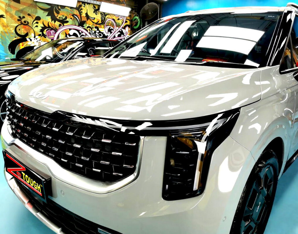 The Kia Carnival's coated paintwork under workshop lighting.