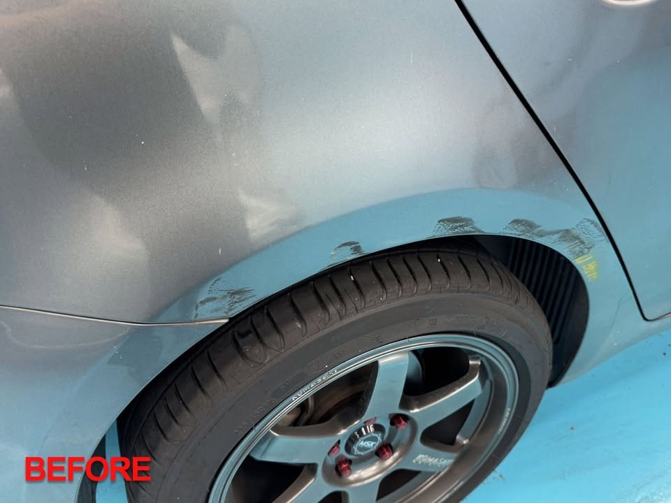 Rear wheel arch of the grey Forte with worn, chipped paint before work.