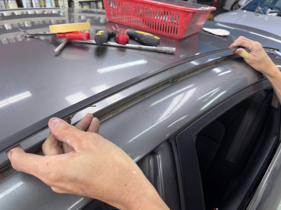 Roof trim strip being pulled off the grey roof edge.