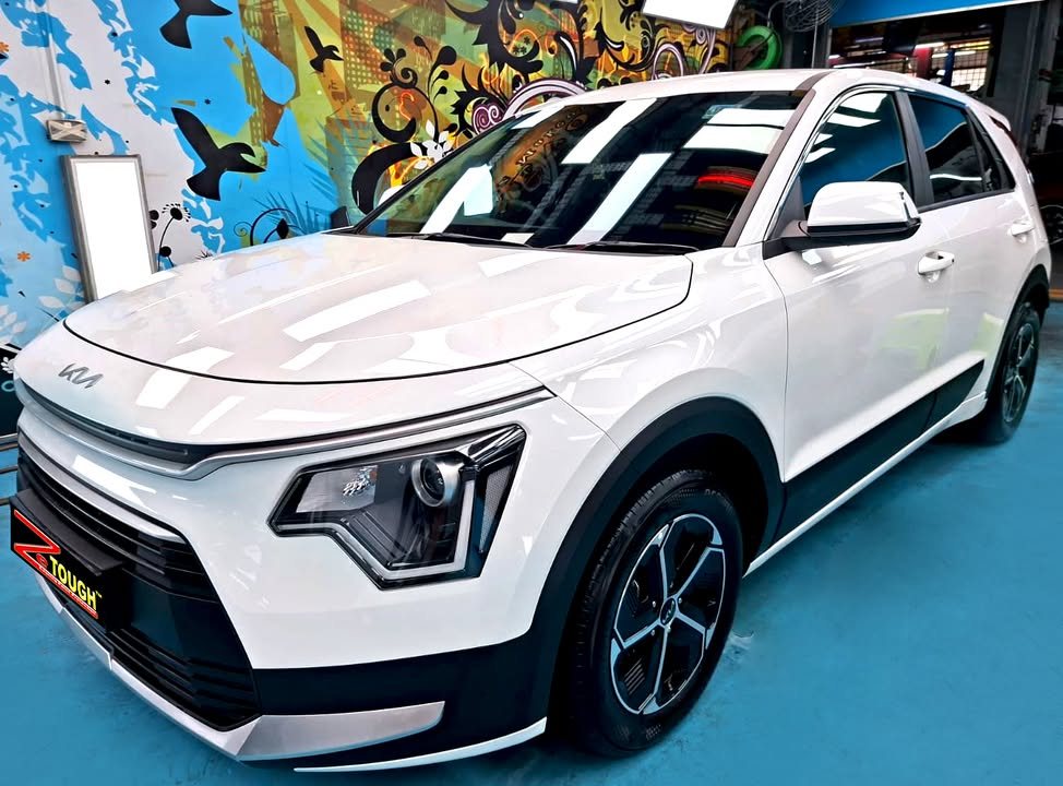White Kia Niro Hybrid, front three-quarter view, in the Revol Carz Makeover workshop after its ZeTough Titanium coating.