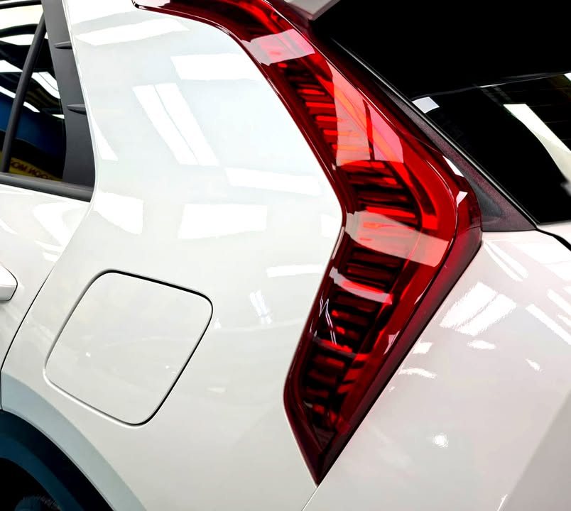 Close-up of the vertical red tail light on the white rear pillar.