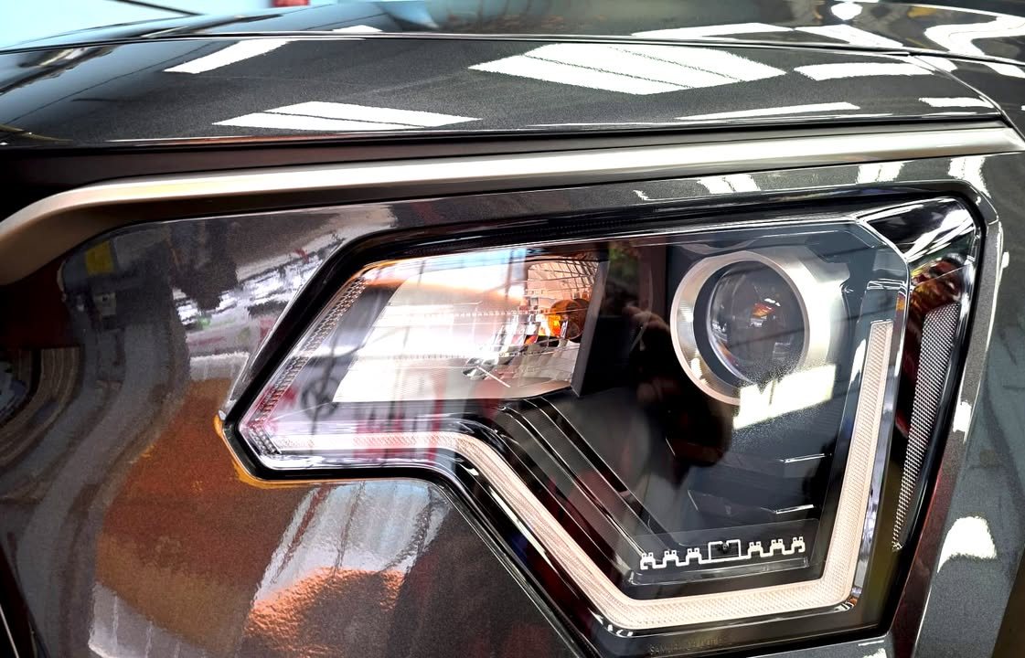 Close-up of the projector headlight framed by the grey wing.