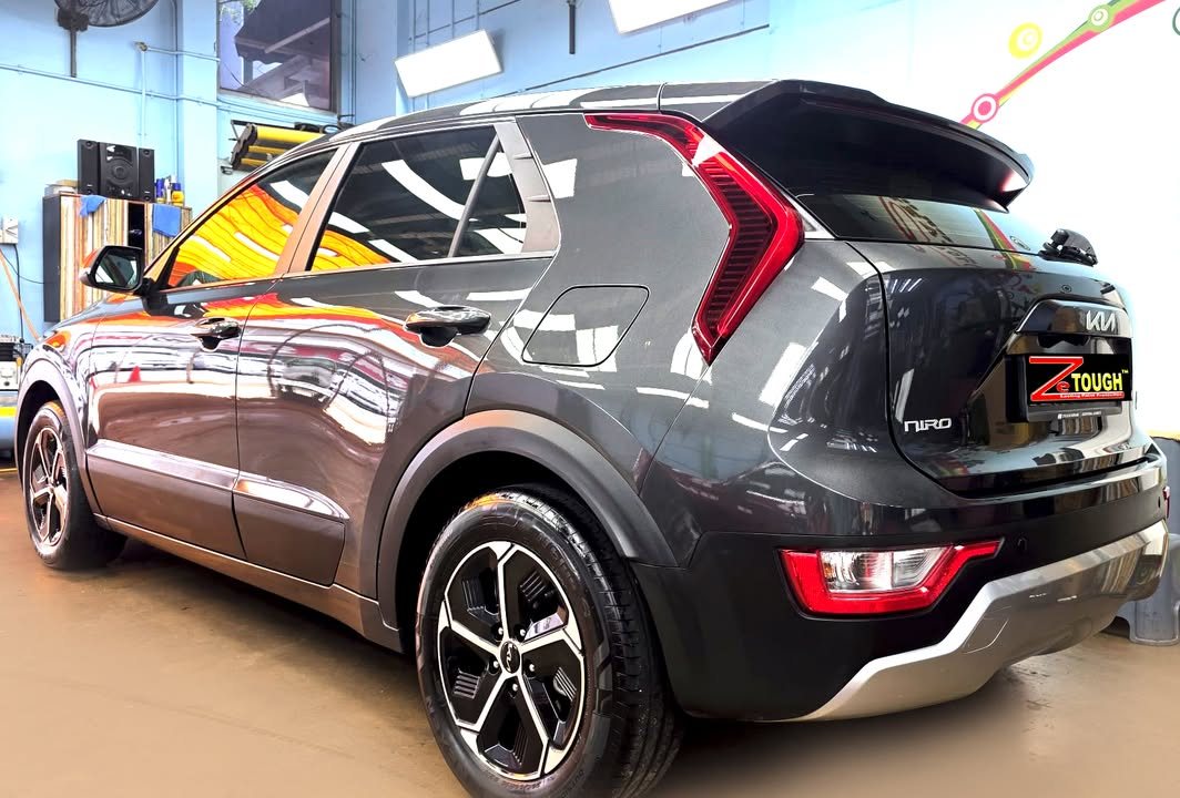 Rear three-quarter view of the Niro with its red boomerang tail lights and two-tone alloy wheels.