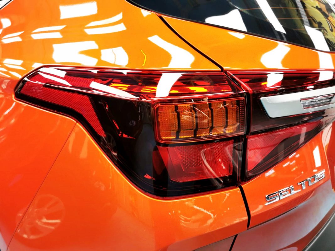Bonnet of the Kia Seltos under workshop lighting.
