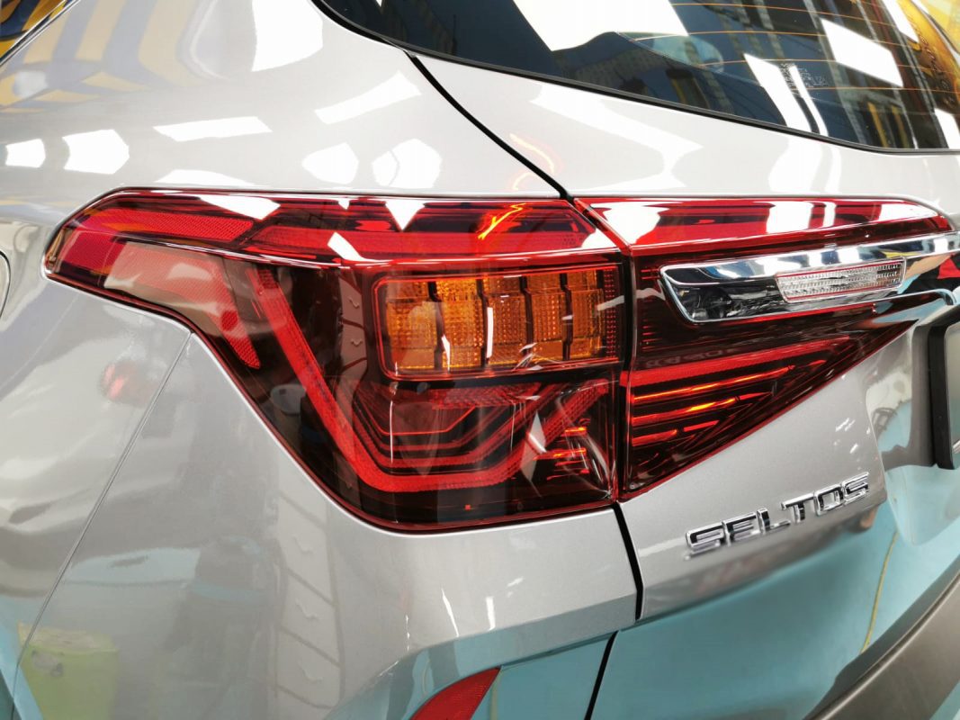 Bonnet of the Kia Seltos under workshop lighting.