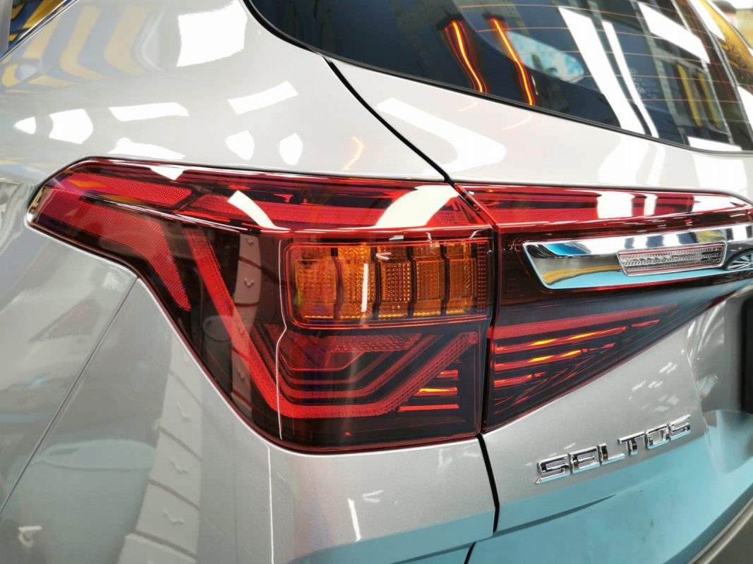 Bonnet of the Kia Seltos under workshop lighting.