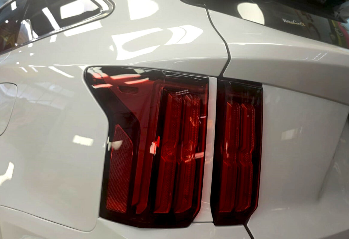 Coated bonnet of the Sorento under workshop lighting.