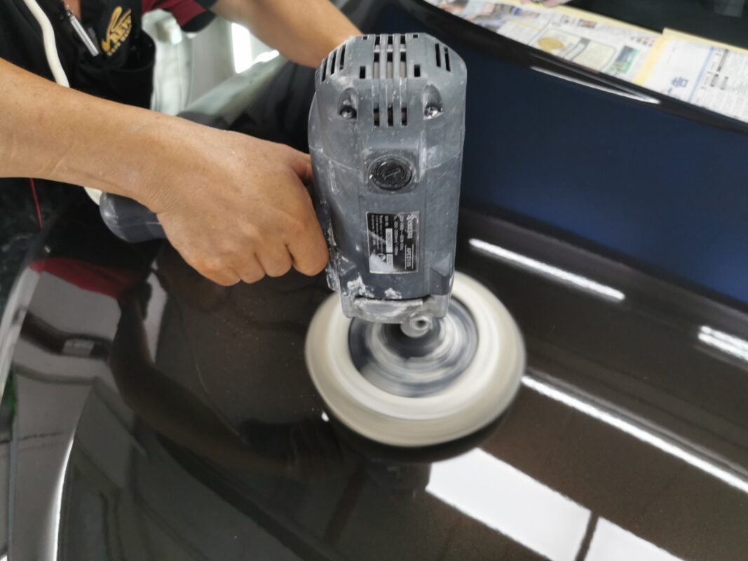 Compound-polishing the Kia Sorento's hood to a mirror finish.