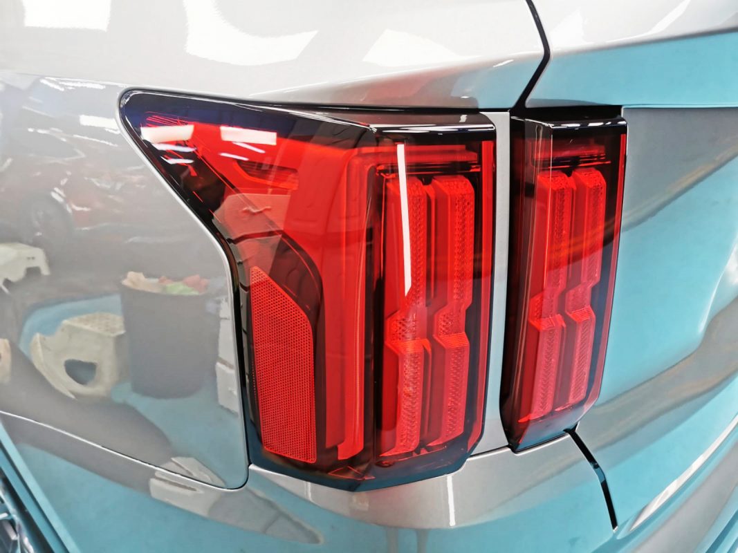 The coated bonnet of the Sorento under workshop lighting.