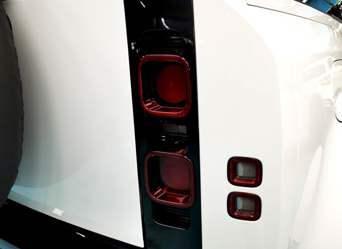 The coated bonnet of the Defender under workshop lighting.
