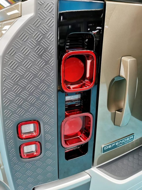 The coated bonnet of the Defender under workshop lighting.