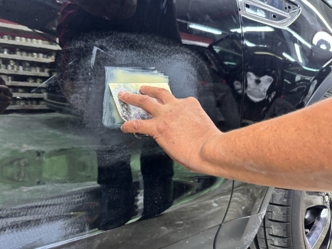 Sanding a panel on the Land Rover Discovery to bring repaired areas level.