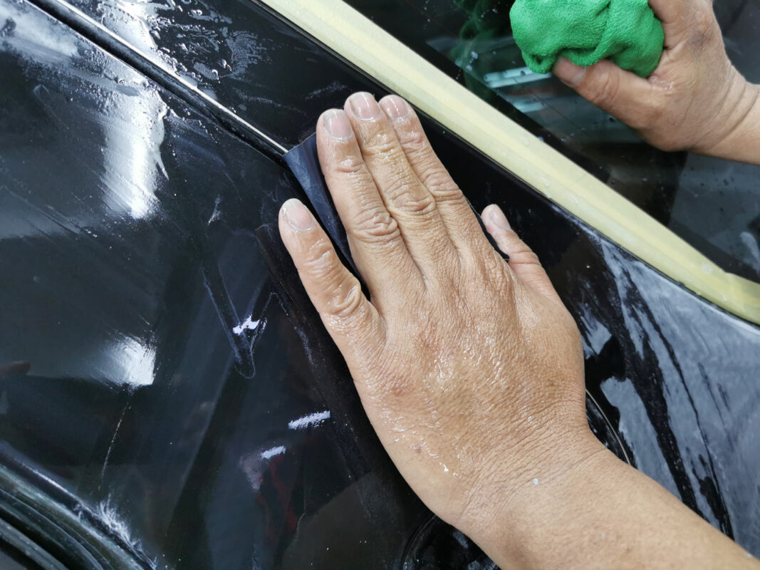 Wet-sanding the Land Rover Discovery after the primer coat is applied.