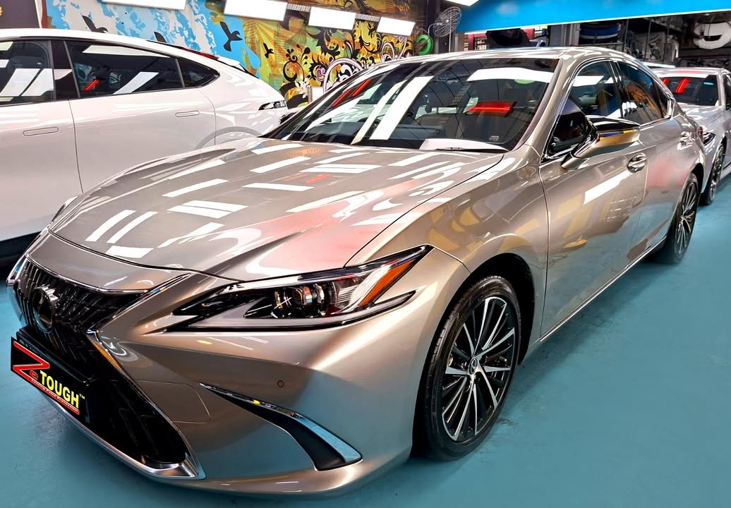 Champagne Lexus ES 300h from the front three-quarter, its bonnet reflecting the workshop lights after the ZeTough Ceramic coating.