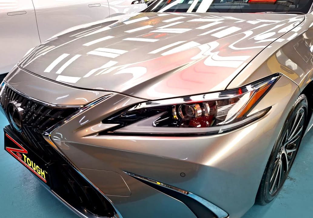 Front of the champagne Lexus ES 300h showing the spindle grille and headlamp.