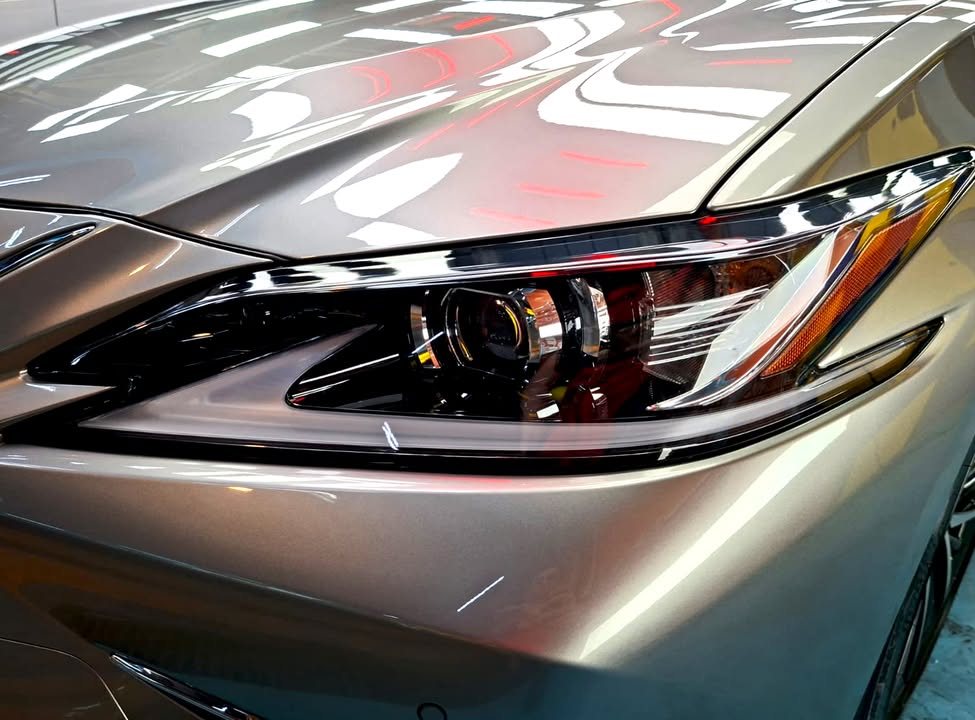 Close-up of the ES 300h headlamp and front wing with light reflections.