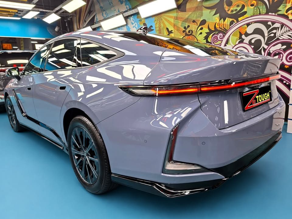 Blue grey Lexus ES 350e, rear three-quarter view, in the workshop.