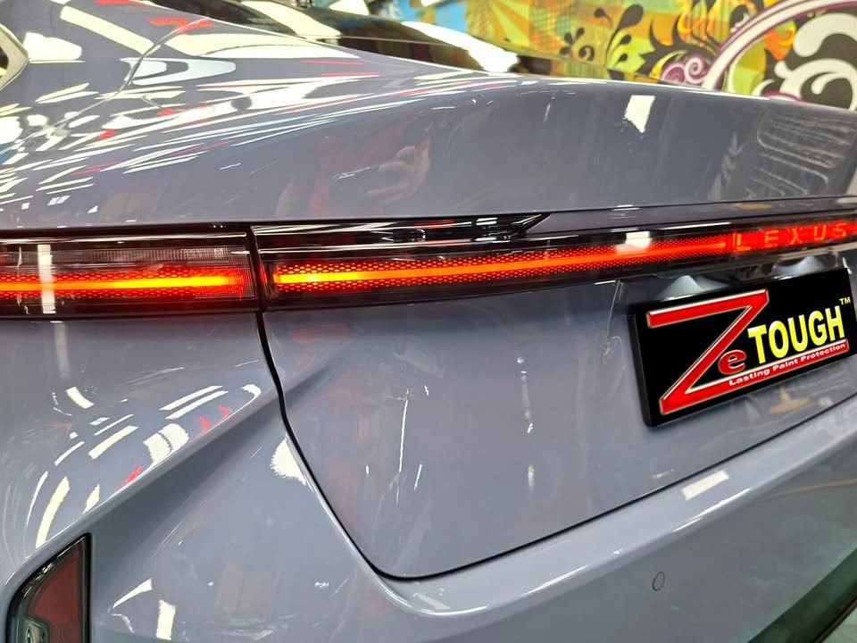 Full-width rear light bar on the blue grey boot lid.