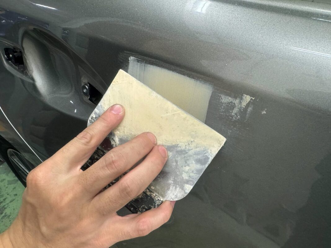Reshaping and repairing the metal panel on the Lexus ES300H.