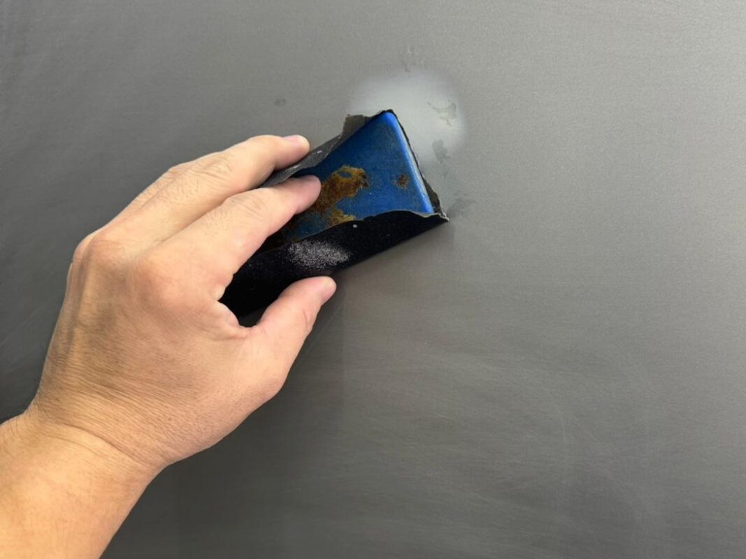 Wet-sanding a panel on the Lexus ES300h to achieve a smooth, level surface before priming.