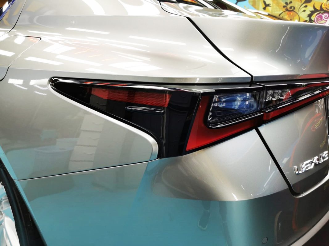 The coated bonnet of the Lexus IS300 under workshop lighting.