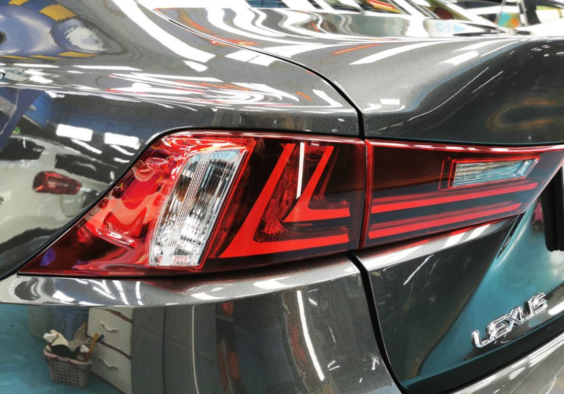 The coated bonnet of the Lexus IS300h under workshop lighting.
