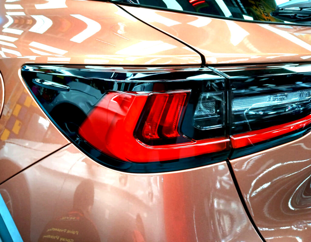 The coated bonnet of the Lexus LBX under workshop lighting.